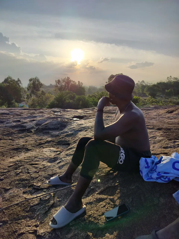 Herman Remington watching the sunset from a rock outcrop